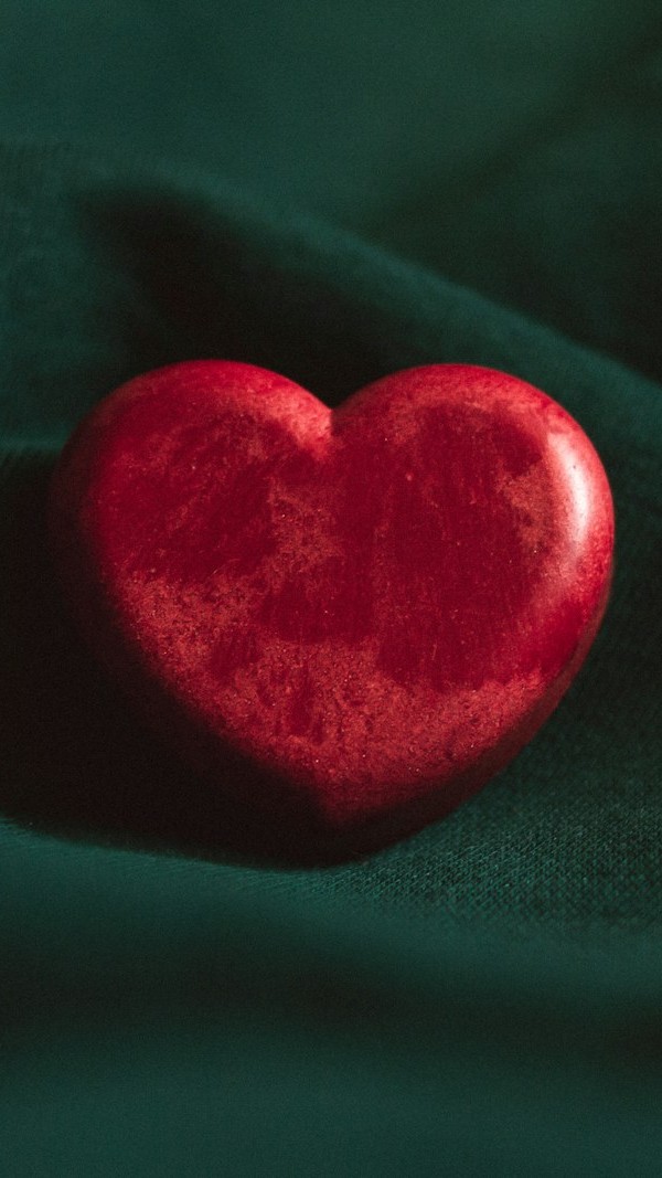 red heart ornament on green textile